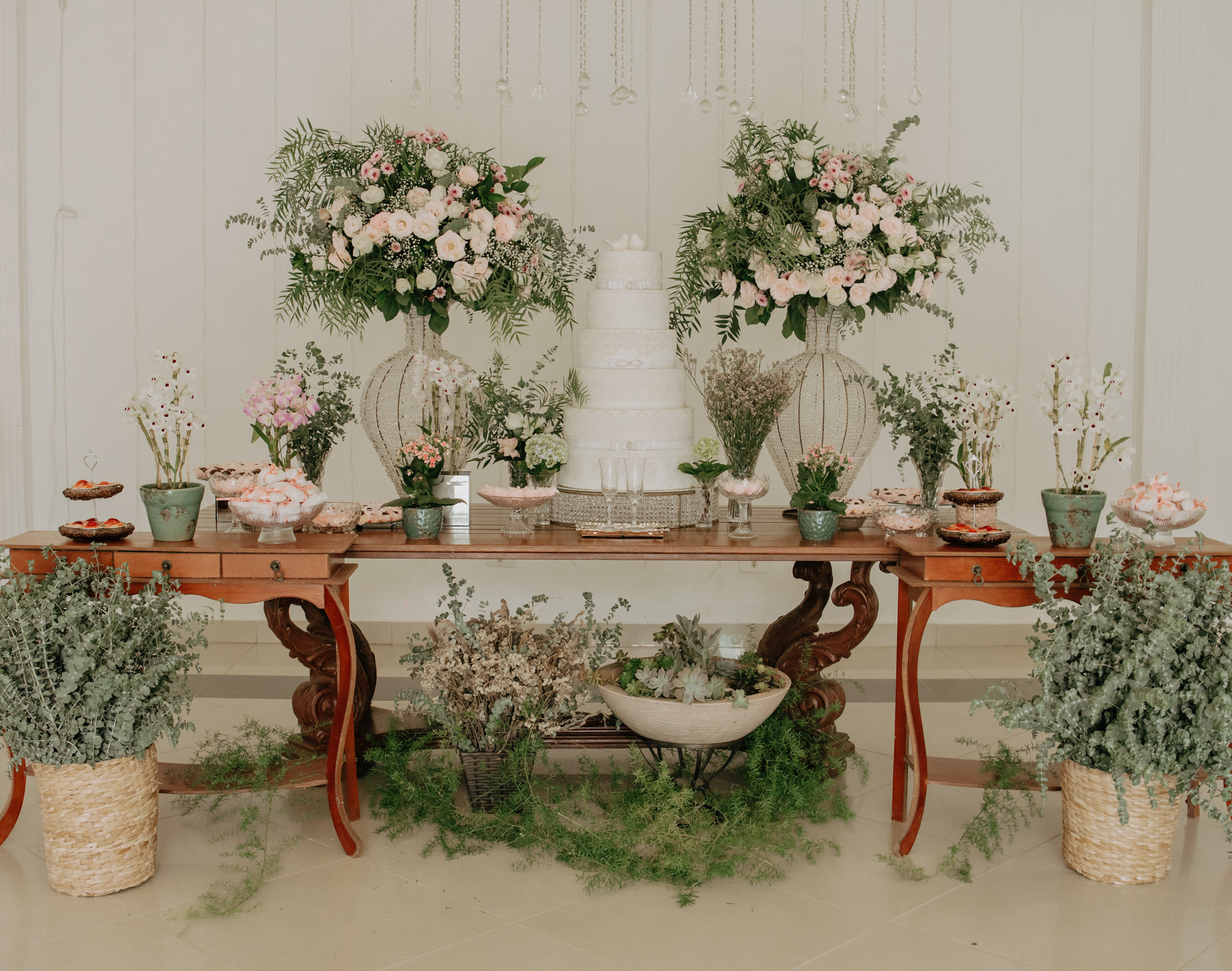 Mesa de celebração com arranjos florais, em outro enquadramento